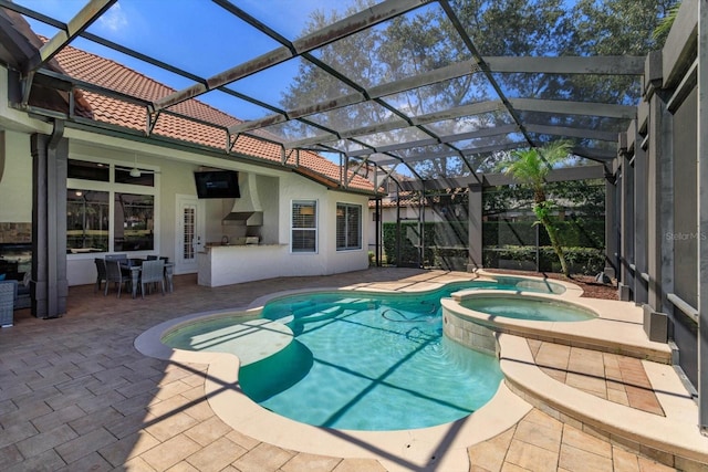 view of swimming pool with glass enclosure, an in ground hot tub, ceiling fan, and a patio area