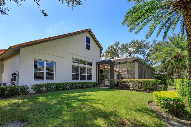 back of house with a sunroom and a yard