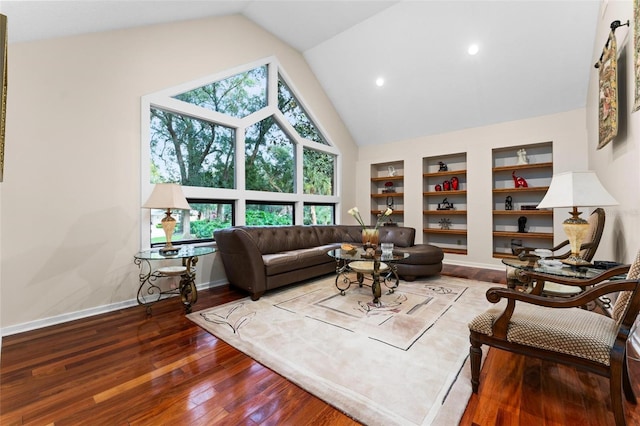 living room with wood-type flooring, built in features, and vaulted ceiling