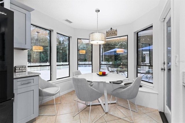 tiled dining space featuring plenty of natural light