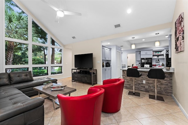 tiled living room featuring ceiling fan and high vaulted ceiling