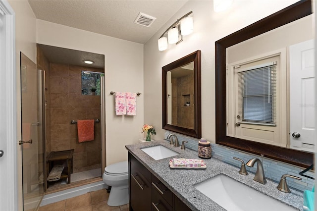 bathroom with a textured ceiling, an enclosed shower, toilet, tile patterned floors, and vanity