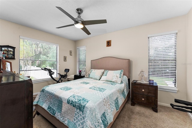 carpeted bedroom with ceiling fan and multiple windows