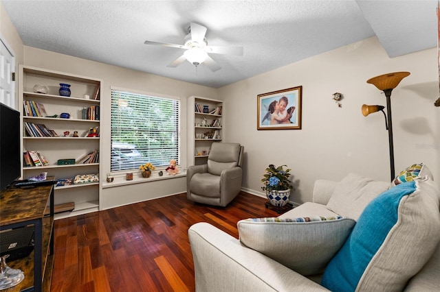 sitting room featuring a textured ceiling, dark wood-type flooring, and ceiling fan