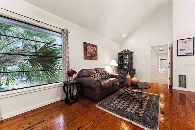 living room with dark hardwood / wood-style floors and high vaulted ceiling