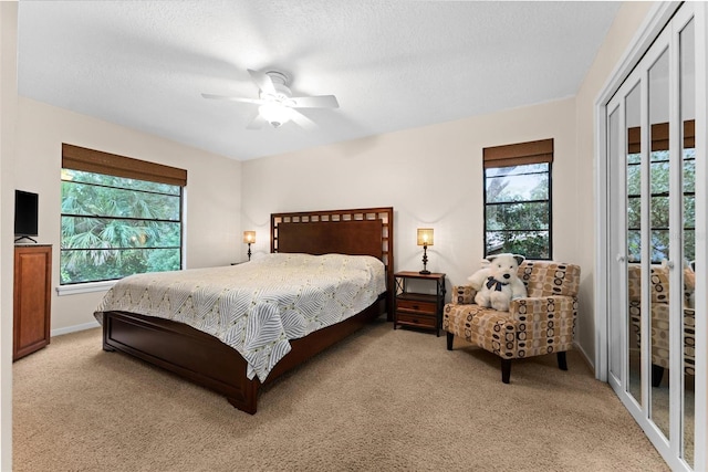 carpeted bedroom featuring a textured ceiling, a closet, and ceiling fan