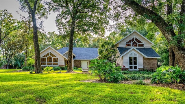 view of front of home with a shingled roof and a front yard