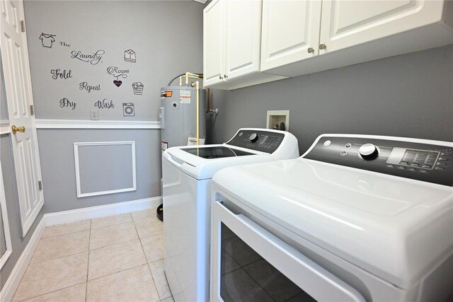 laundry room featuring light tile patterned flooring, electric water heater, washing machine and dryer, and cabinets