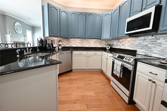 kitchen with blue cabinetry, sink, white cabinets, and stainless steel appliances