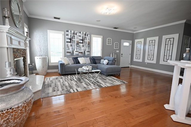 living room with crown molding, wood-type flooring, and a fireplace