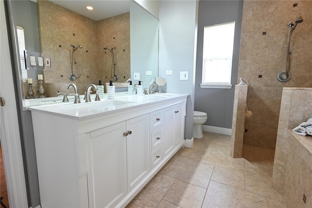 bathroom with tile patterned floors, tiled shower, toilet, vanity, and tasteful backsplash