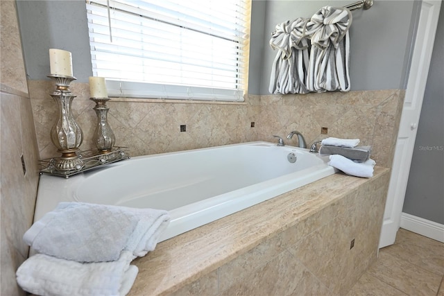 bathroom with tiled tub and tile patterned flooring