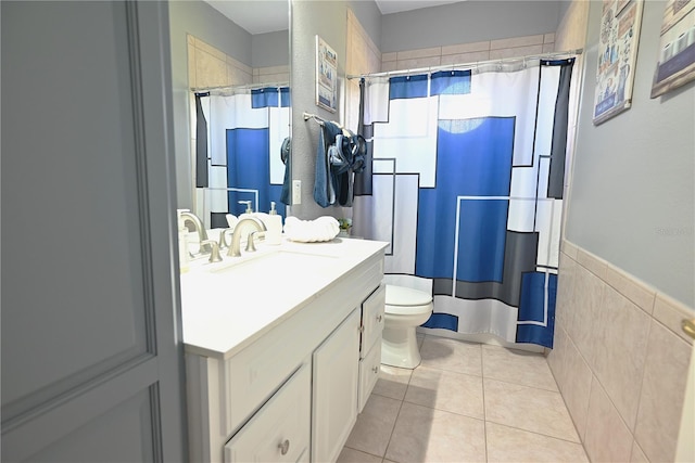 bathroom featuring walk in shower, tile walls, toilet, vanity, and tile patterned flooring