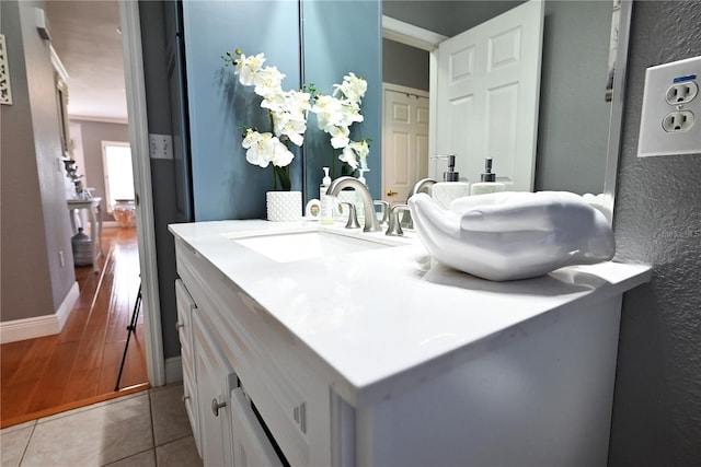 bathroom featuring vanity, crown molding, and wood-type flooring