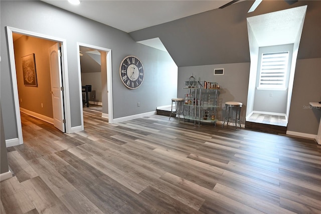 additional living space with hardwood / wood-style floors, vaulted ceiling, and ceiling fan