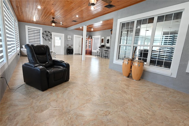 living room with a healthy amount of sunlight, decorative columns, wooden ceiling, and ceiling fan