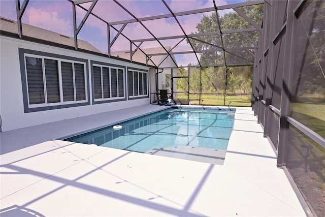 pool at dusk with a patio and a lanai