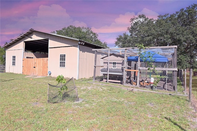 yard at dusk featuring an outdoor structure