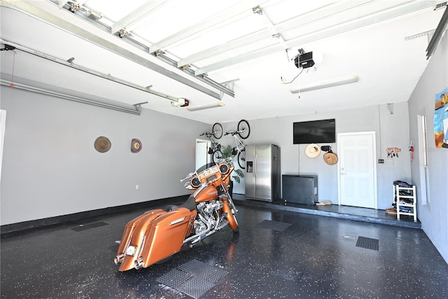 garage featuring a garage door opener and stainless steel fridge