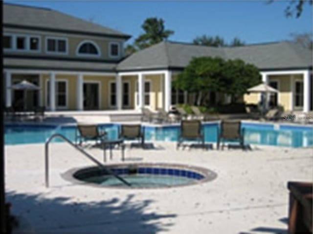 view of pool with a community hot tub and a patio area