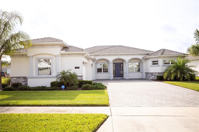 mediterranean / spanish home featuring a front yard