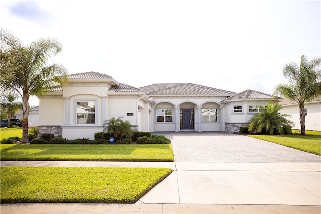 mediterranean / spanish home featuring a front lawn