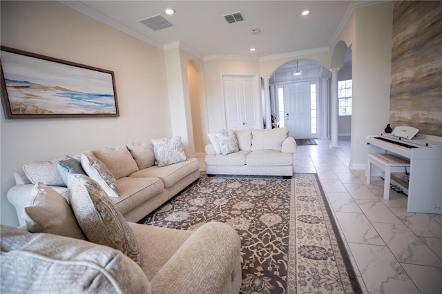 living room with ornamental molding and decorative columns