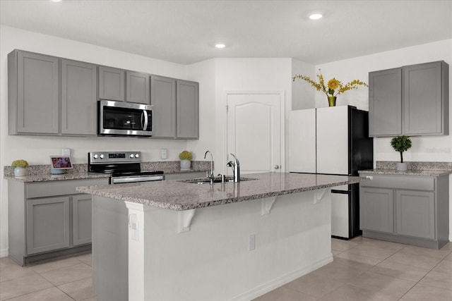 kitchen with gray cabinets, a kitchen island with sink, sink, and stainless steel appliances