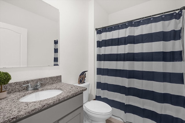 bathroom featuring a shower with curtain, vanity, and toilet