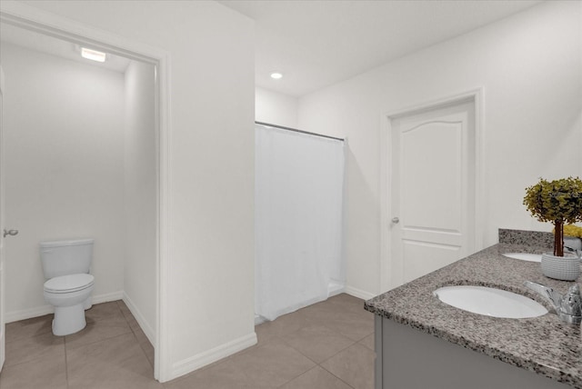 bathroom with walk in shower, vanity, toilet, and tile patterned floors