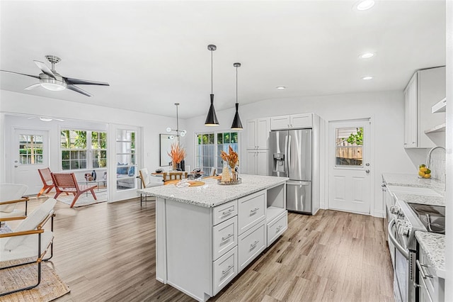 kitchen with decorative light fixtures, white cabinetry, ceiling fan, a kitchen island, and appliances with stainless steel finishes