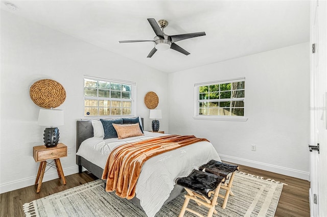 bedroom featuring lofted ceiling, multiple windows, ceiling fan, and dark hardwood / wood-style floors