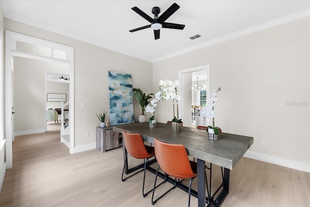 home office featuring light wood-style flooring, baseboards, visible vents, and ornamental molding