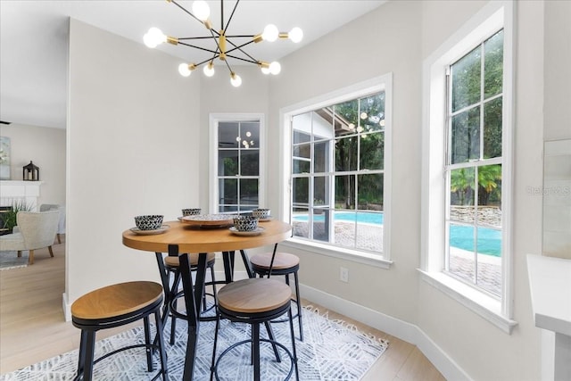 dining area with wood finished floors, a notable chandelier, and baseboards