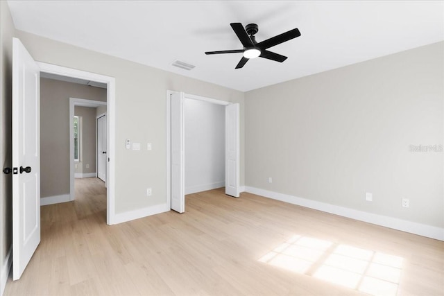 unfurnished bedroom with visible vents, baseboards, a closet, a ceiling fan, and light wood-style floors