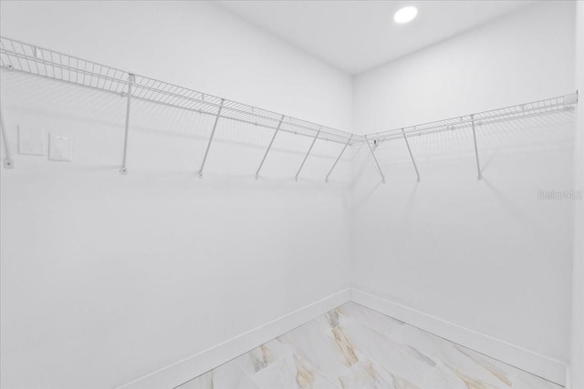 spacious closet featuring marble finish floor