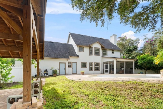 back of house with a yard, a sunroom, and a patio area