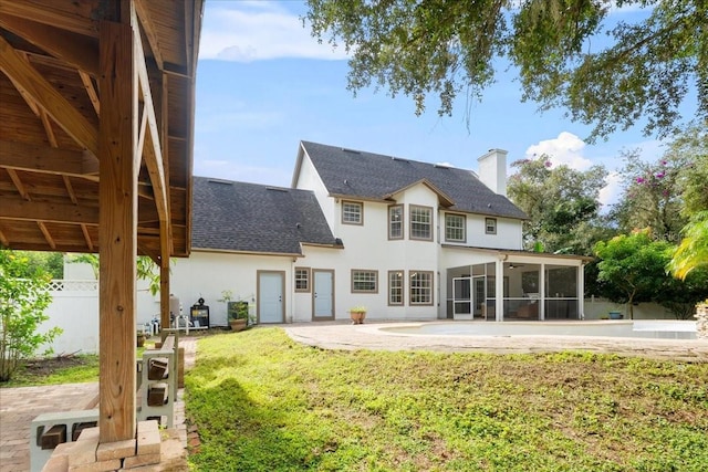 back of property with a sunroom, stucco siding, roof with shingles, a patio area, and fence