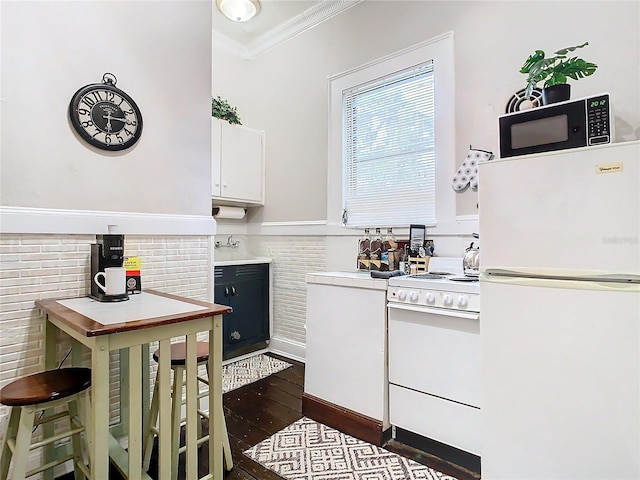 kitchen with crown molding, white cabinets, dark wood-type flooring, and white appliances