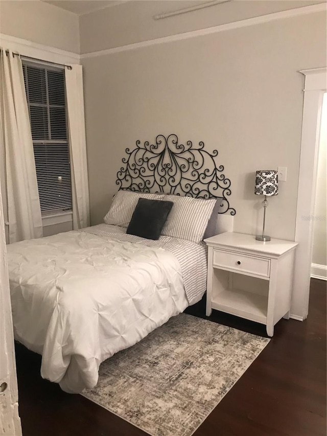 bedroom with dark hardwood / wood-style floors