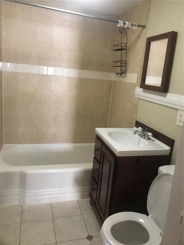 full bathroom featuring tile patterned floors, vanity, tiled shower / bath combo, and toilet