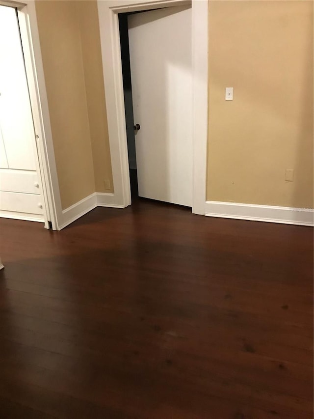 unfurnished room featuring dark wood-type flooring