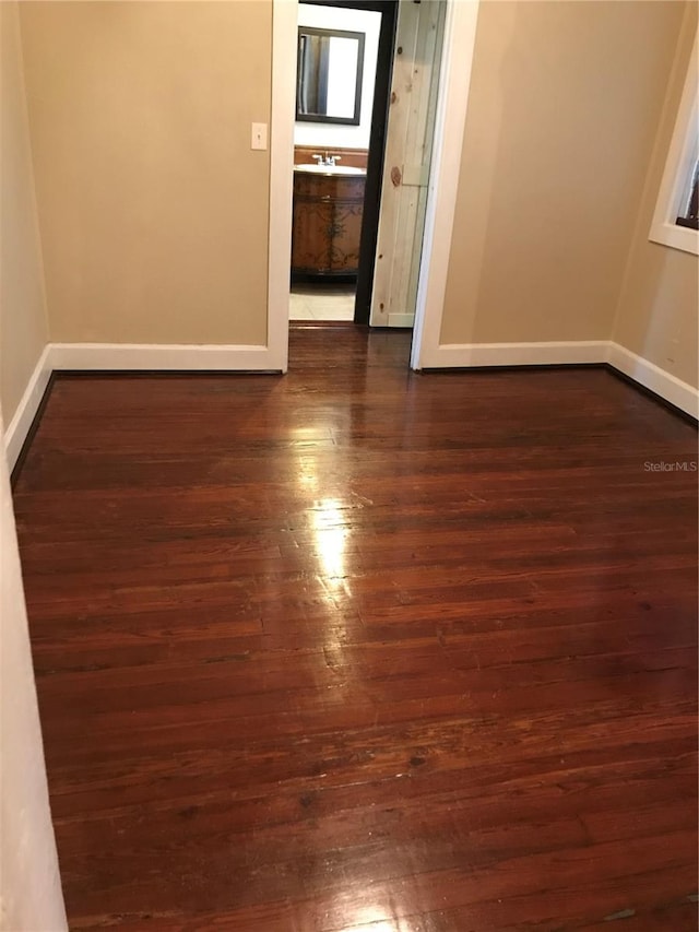 spare room with dark wood-type flooring and sink