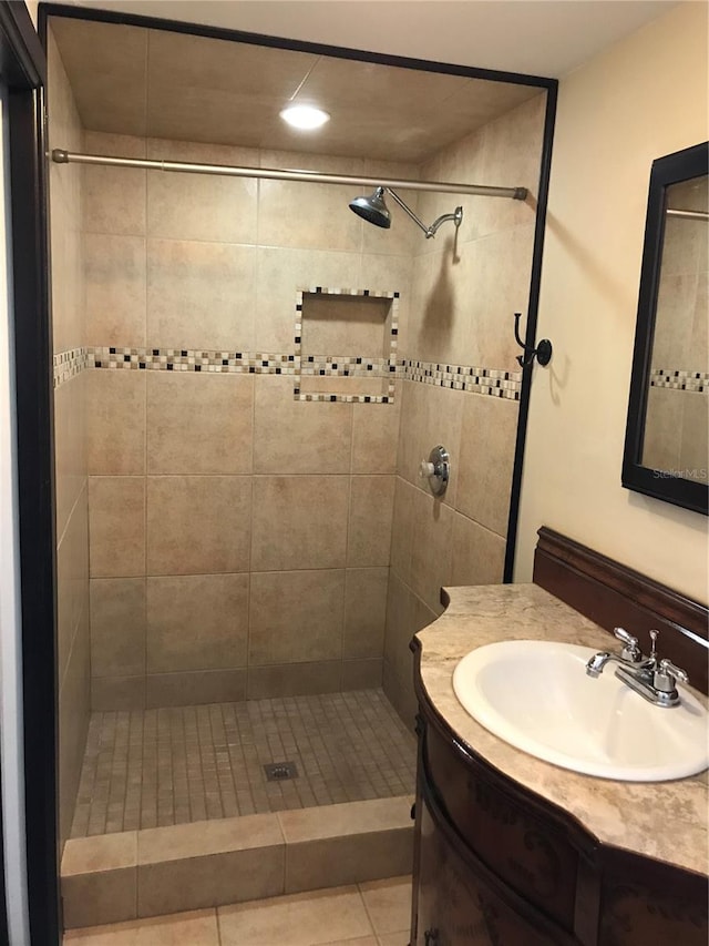 bathroom featuring tiled shower, vanity, and tile patterned floors