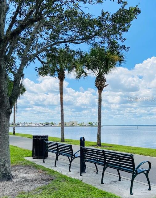 view of property's community with a lawn and a water view