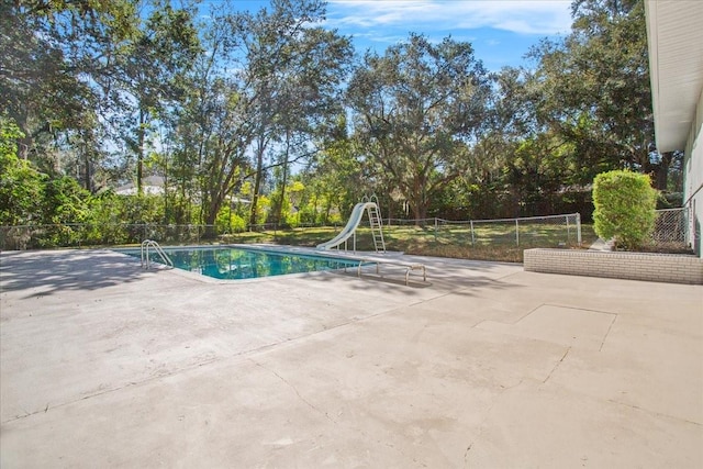 view of pool featuring a water slide, a patio area, fence, and a fenced in pool