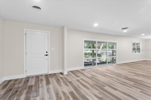 interior space with wood finished floors, visible vents, and baseboards