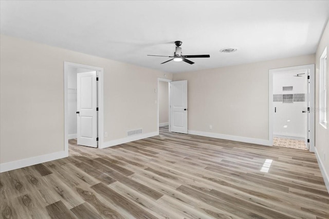 unfurnished bedroom featuring light wood-type flooring, baseboards, a spacious closet, and visible vents