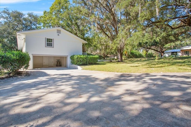 view of home's exterior featuring a garage, stucco siding, and a yard