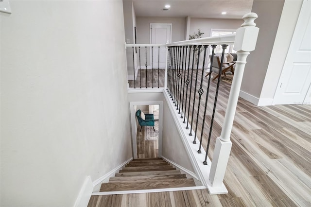 staircase featuring baseboards and wood finished floors